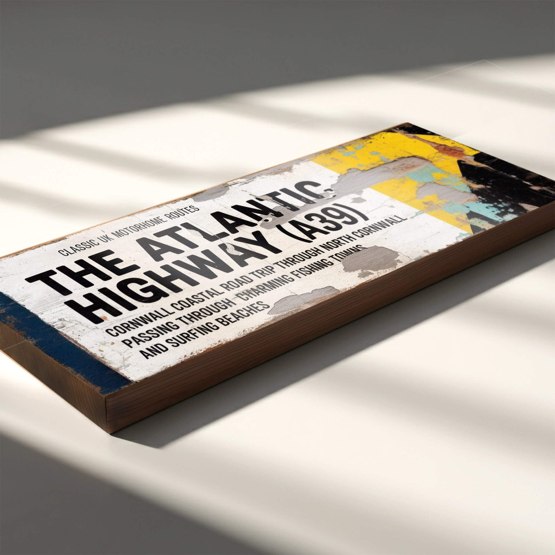 A rectangular vintage-style road sign on 18mm MDF for The Atlantic Highway A39. Features black text on a white background with a blue stripe, yellow arrow, and heavy integrated faux-rust and weathered paint effects.