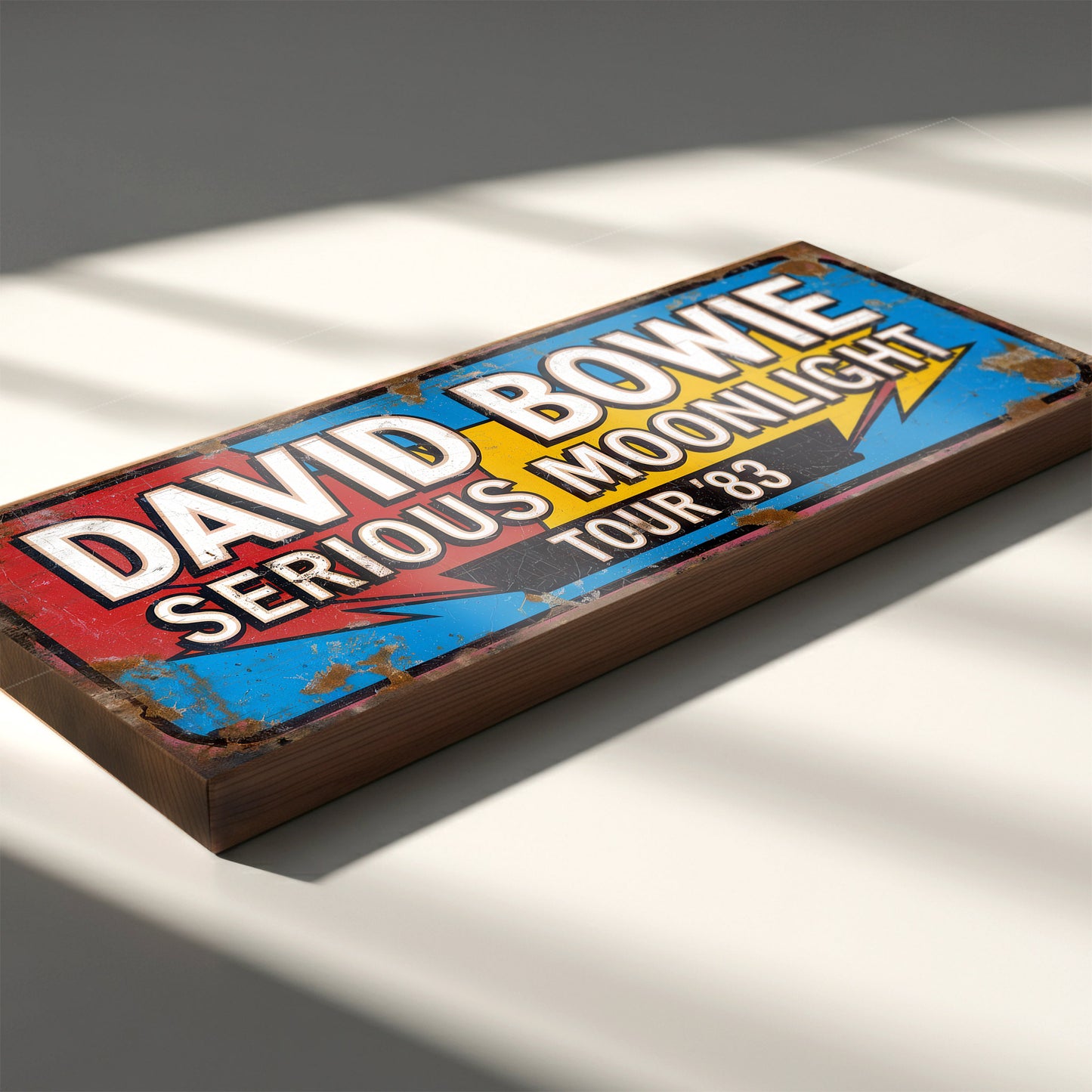 A rectangular vintage-style concert sign on 18mm MDF for David Bowie's Serious Moonlight Tour '83. The design features bold white lettering on a red, blue, and yellow background with heavy faux-rust weathering effects.
