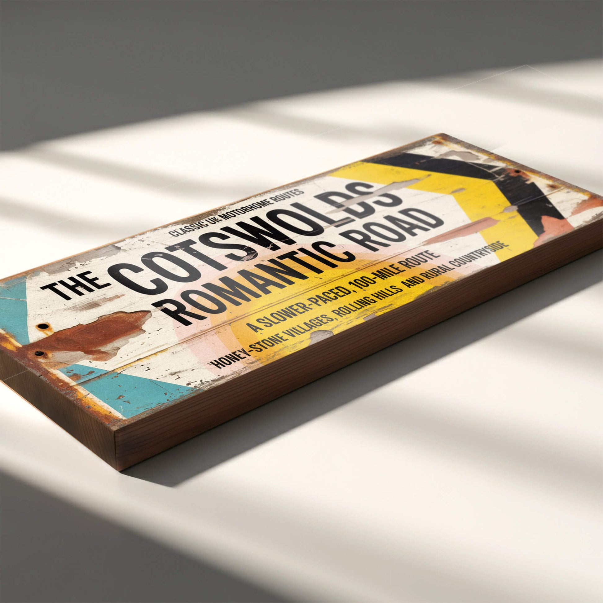 A rectangular vintage-style road sign on 18mm MDF for The Cotswolds Romantic Road. Features black text on a white background with turquoise and yellow accents and heavy integrated faux-rust and weathered paint effects.