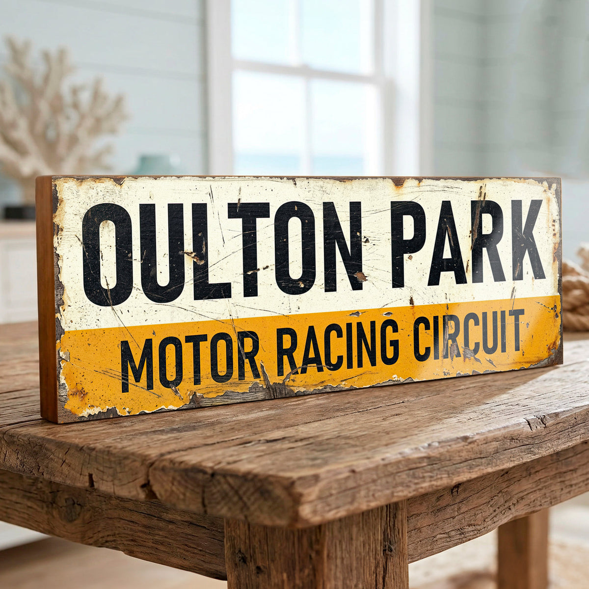 Rectangular vintage style Oulton Park Motor Racing Circuit sign with distressed off-white and yellow graphic on 18mm MDF, freestanding on a rustic wooden table