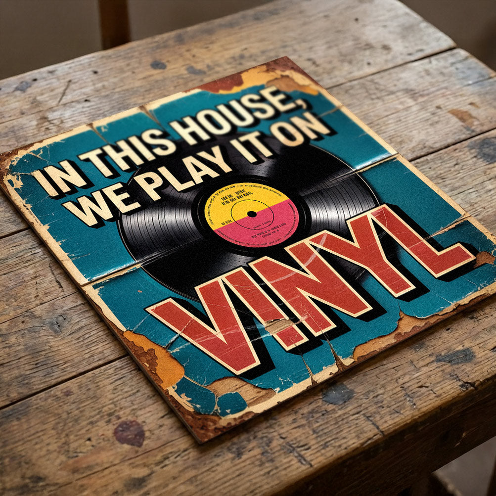 A square 31cm x 31cm vintage-style music sign on 9mm MDF with a vinyl record graphic and "IN THIS HOUSE, WE PLAY IT ON VINYL" text. Features a teal background with heavy integrated faux-flaking paint and rust effects.